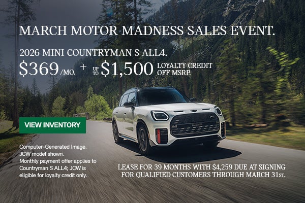 Front passenger view of a white MINI Countryman  driving on a mountainous road.