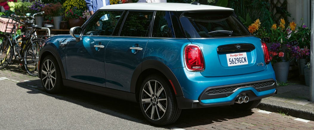 side view of the MINI Hardtop 4 Door parked in front of a shop.