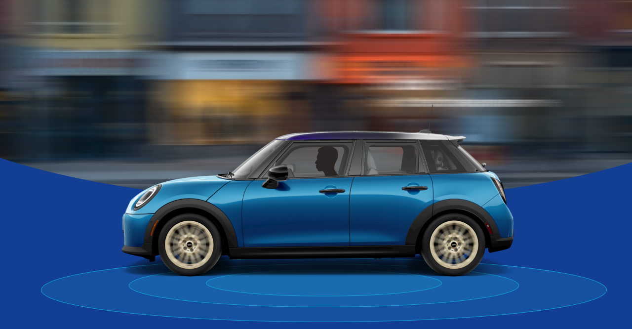 The side-view of a Mini Cooper 4 Door with a blurred city street in the background and blue rings beneath it. 
