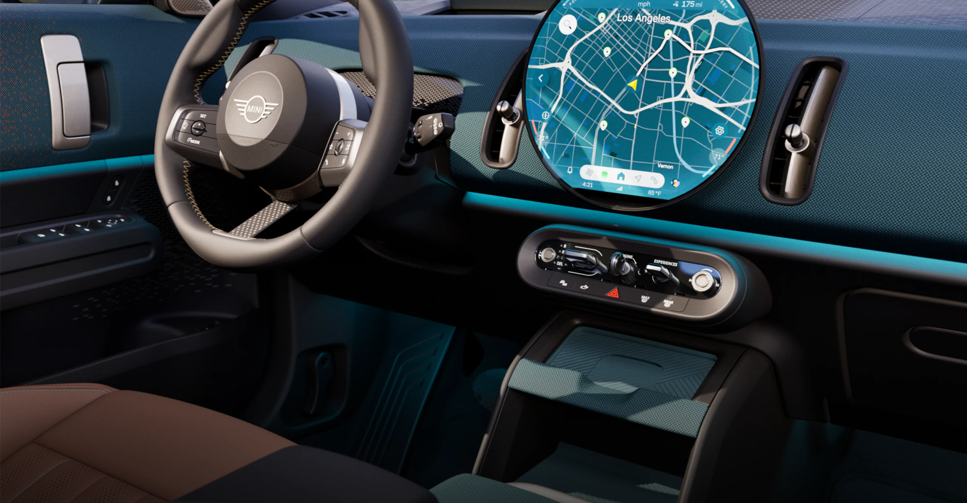 An image of the inside of the MINI Countryman S ALL4 taken from the passenger's side, showcasing the dashboard, steering wheel, and display. 